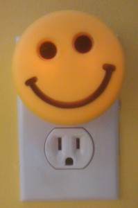 Smiley face night light plugged into electrical outlet