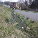 shopping trolley ditched in grass off trail