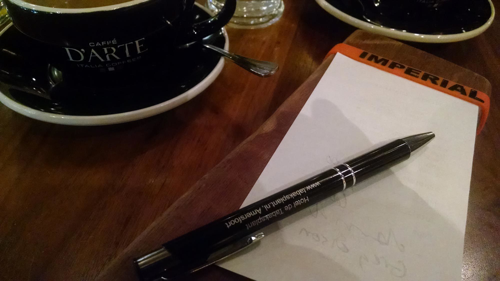image of Greg Olson notepad at Cafe Darte with Hotel de Tabaksplant for contact us header image on delightability website