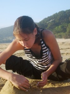image of girl designing sand castle as we all do at early ages where we naturally discover our inner designer